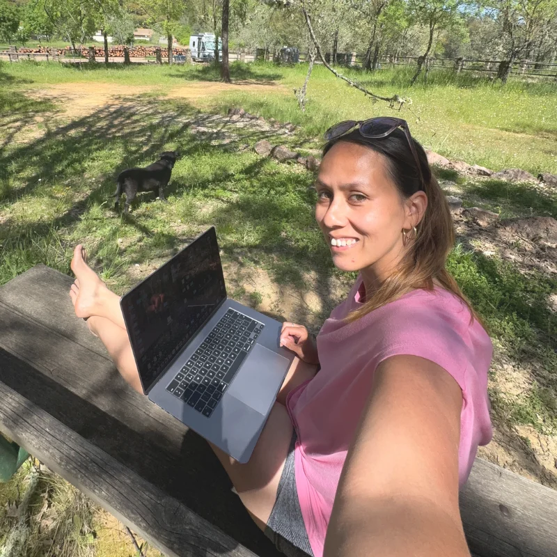 Niky pracuje online na lavičce, v pozadí dodávka Dory a Bruno