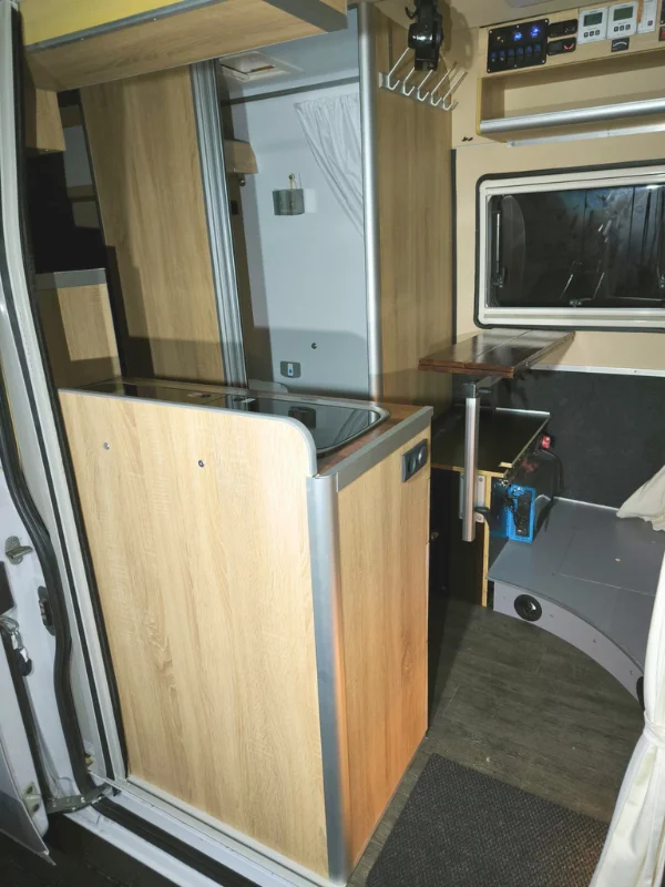 Interiér obytné dodávky Fiat Ducato, pohled z bočních posuvných dveří.